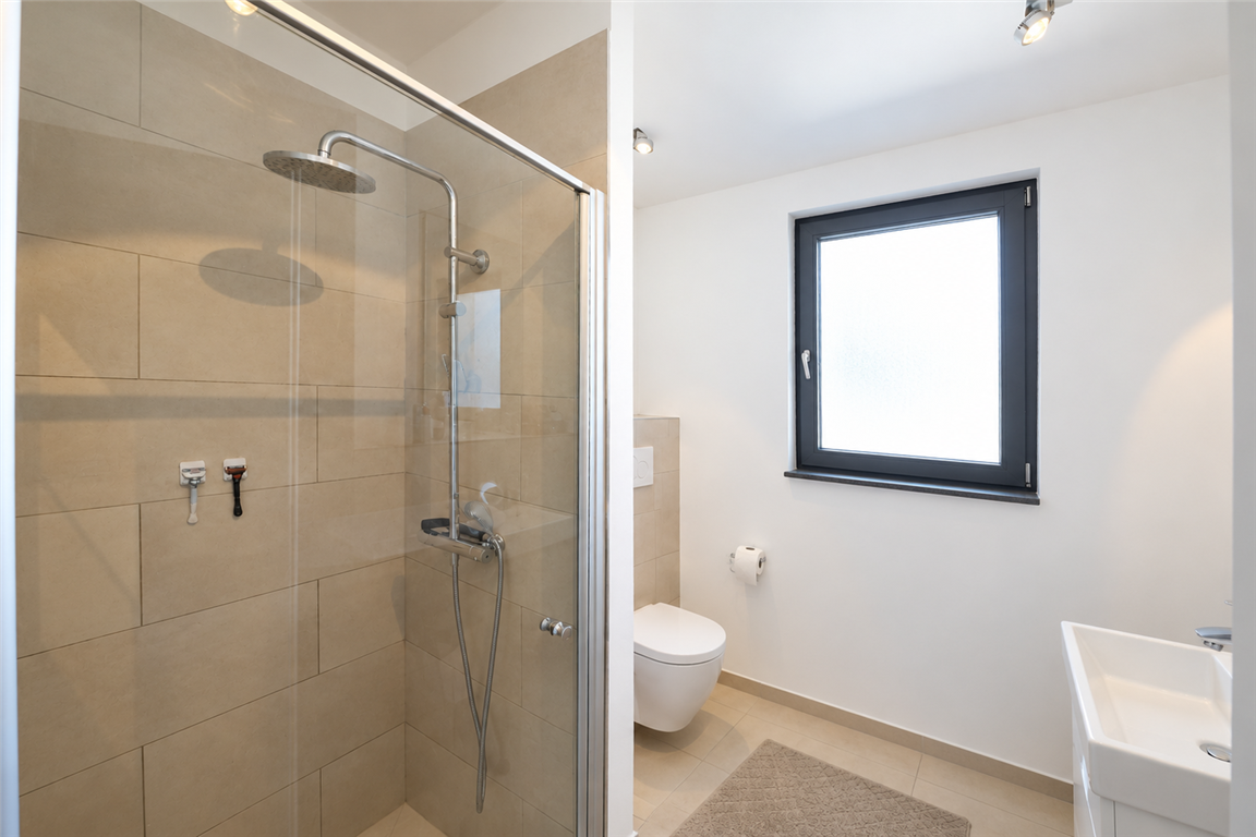 Modernes, helles Badezimmer mit Glasdusche
